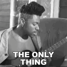 a black and white photo of a man playing a guitar with the words " the only thing " above him