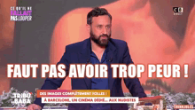 a man with a beard stands in front of a sign that says faut pas avoir trop peur