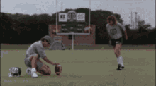 a man kneeling on a field with a football and a girl wearing a shirt that says ts on it