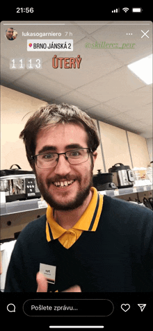 a man with glasses and a yellow shirt is smiling in a kitchen