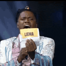 a man holding a piece of paper that says liema