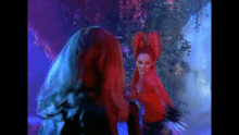 a woman with red hair is standing next to another woman with red hair