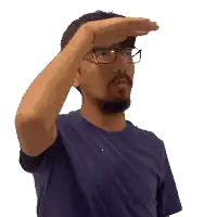 a man wearing glasses and a blue shirt is covering his eyes with his hand