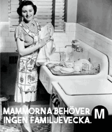 a woman in an apron is washing dishes in a kitchen