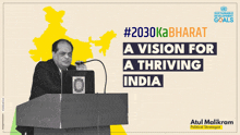 a man stands at a podium with a microphone in front of him and the words # 2030kabharat a vision for thriving india