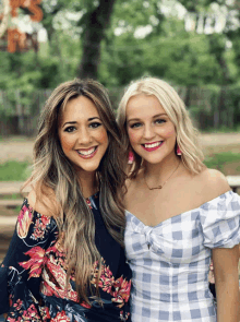 two women are posing for a picture and one has a necklace that says ' faith ' on it