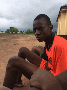 a young man wearing an orange shirt with the letter c on it