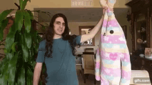 a man with long hair is holding a stuffed animal that says " i love you " on it