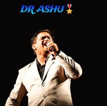 a man in a suit singing into a microphone with the name dr. rashu above him