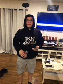 a person wearing a psn masters hoodie holds a can of soda