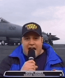 a man wearing a hat that says chuck larry is talking into a microphone