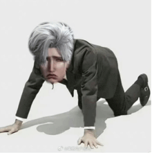 a man in a suit is crawling on his knees with a sad face on his face .