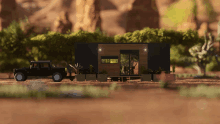 a black truck is parked in front of a small house in the desert