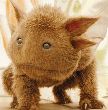 a stuffed animal with a sad look on its face is standing on its hind legs