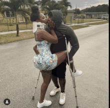 a man with crutches kisses a woman with a neck brace on her head