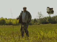 a man in a striped shirt is standing in a grassy field with a sign that says ' a ' on it