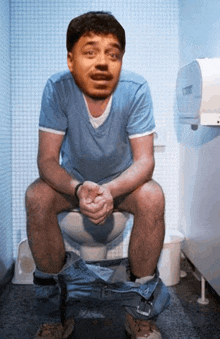 a man sits on a toilet with his pants down