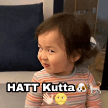 a little girl sitting on a couch with a picture of a dog and the words hatt kutta