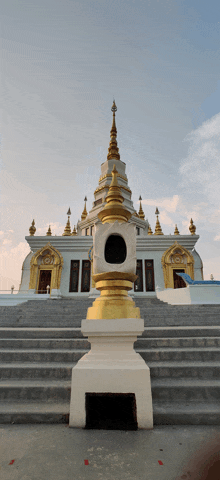 a white and gold building with stairs leading up to the top