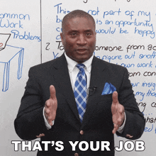 a man in a suit and tie is standing in front of a white board that says " that 's your job "