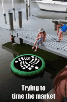 a woman sits on a dock next to a green float that says " trying to time the market "