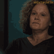 a woman holding a cup with the word wentworth on the bottom right