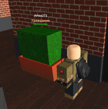 a brick wall with a green cube in front of it and the name artoa271 on it