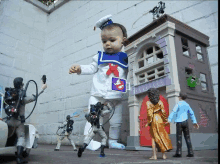 a baby in a ghostbusters costume stands in front of a toy house