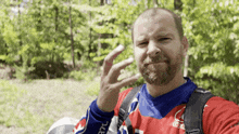 a man with a beard wearing a red blue and white jersey with the word coca cola on the sleeve