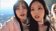 a couple of girls are standing next to each other and making funny faces .