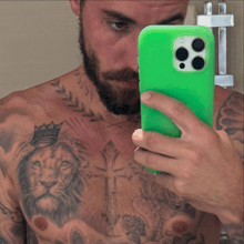 a man is taking a selfie with a green cell phone