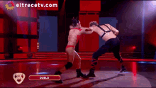 a man and a woman are wrestling on a stage and the website eltrecetv.com is visible in the corner