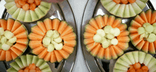 a tray of melons cut into flowers on a silver plate