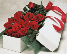 a box filled with red roses with a red ribbon