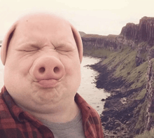 a man with a pig 's nose is making a funny face with his eyes closed