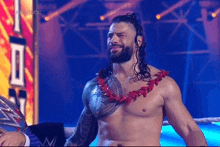 roman reigns is wearing a lei around his neck while standing in a ring .