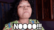 a woman with curly hair is wearing a green shirt that says nooo !!!