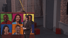 a man in a suit and tie is standing in front of a colorful puzzle with pictures of people on it