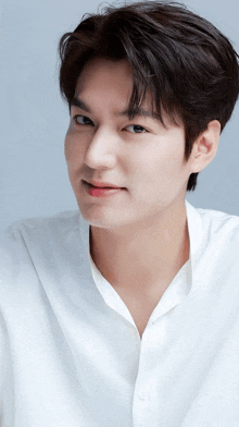 a close up of a man 's face with a white shirt