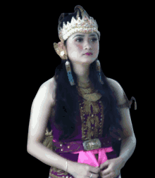 a woman wearing a purple and gold outfit and a crown