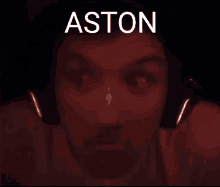 a man wearing headphones with the name aston written on the bottom