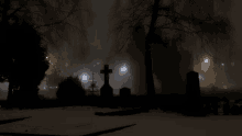 a cemetery with a cross in the middle of the night