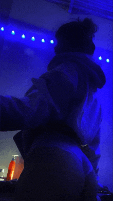 a person taking a selfie in a dark room with blue lights behind them