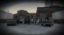 a group of people are posing for a picture in a parking lot with a bmw on the right