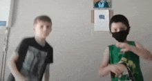 two boys wearing masks are dancing in a room .