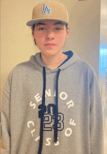 a person wearing a la hat and a hoodie