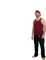 a man wearing a red tank top and black pants is looking up