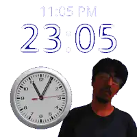a man is standing next to a clock that says 11:05 pm
