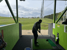 a man is swinging a golf club at a golf course