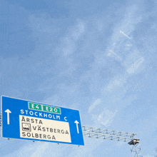 a blue and white highway sign points towards stockholm